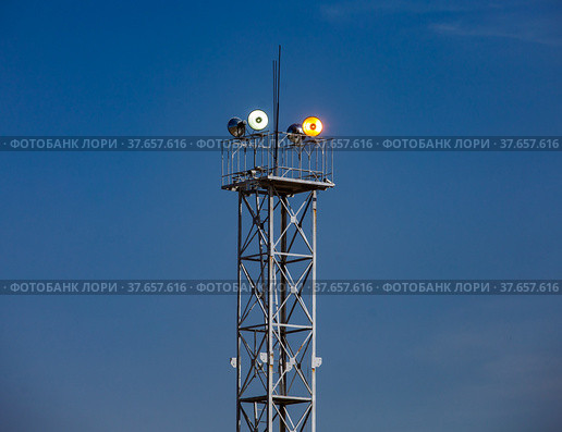 Lighting mast with floodlight at oil refinery plant against blue sky background. Стоковое фото, фотограф Alexey Rezvykh / Фотобанк Лори