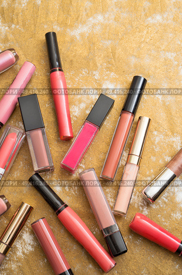 lip gloss in assortiment around golden backround. Стоковое фото, агентство Ingram Publishing / Фотобанк Лори