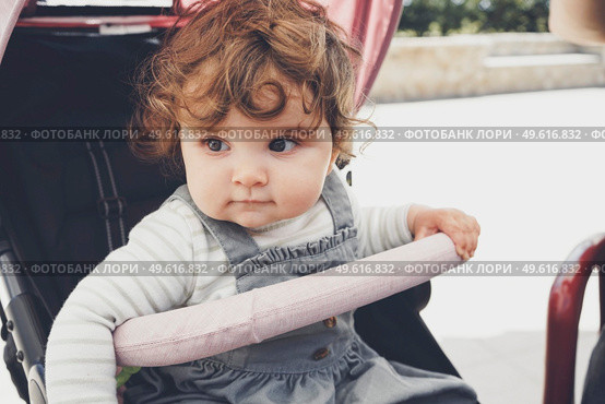 Little baby sitting in her pram for a walk. Стоковое фото, агентство Ingram Publishing / Фотобанк Лори