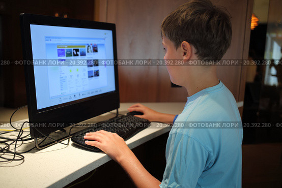 Little boy is surfing internet alone in the room. Стоковое фото, фотограф Losevsky Pavel / Фотобанк Лори