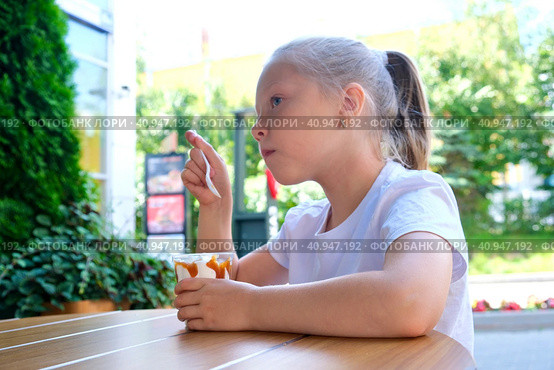 Little girl (child) eating ice cream on the street. Summer. Ice Cream eating. Стоковое фото, фотограф Терехова Марина / Фотобанк Лори