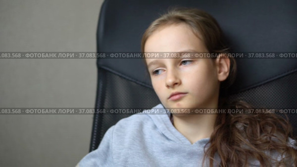 Little sad girl is sitting on black office chair, punishment, serious face. Стоковое видео, видеограф Ольга Балынская / Фотобанк Лори