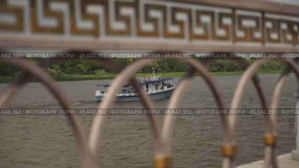 Лодка на реке через ограду. Астрахань. Стоковое видео, видеограф Рустам Солтукием / Фотобанк Лори