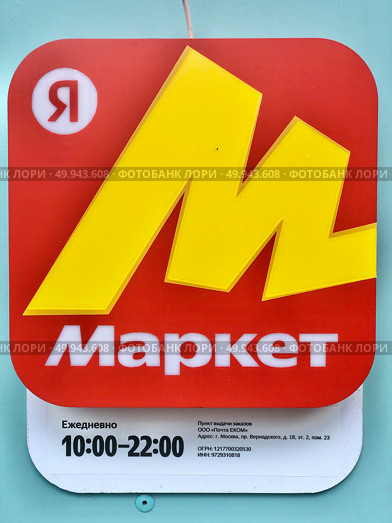 Логотип Яндекс.Маркет на красном фоне и часы работы отделения ПВЗ. Редакционное фото, фотограф Иван Синайко / Фотобанк Лори