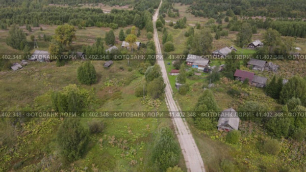 Lonely country road between low wooden houses. Стоковое видео, видеограф Гурьянов Андрей / Фотобанк Лори
