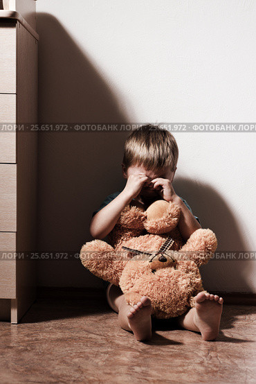 Lonely sad boy crying in corner, holding toy bear. Стоковое фото, фотограф Pavel Biryukov / Фотобанк Лори