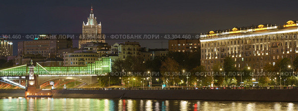 Long exposure photography of Moscow cityscape during autumn night. Blurred lights. Stalinist architecture - building of Ministry of foreign affairs. Bogdan Khmelnitsky Bridge (Kiev Pedestrian Bridge) 2022. Редакционное фото, фотограф YuryKara / Фотобанк Лори