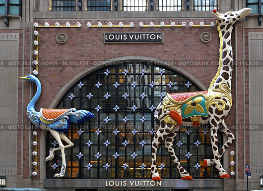 Louis Vuitton’s new NYC flagship. Facade of Art Deco building adorned with giant ostrich and giraffe against backdrop of twinkling Vuitton Monogram flowers. Редакционное фото, фотограф Валерия Попова / Фотобанк Лори
