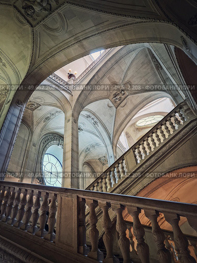 Louvre museum Palais architectural details of a hall with stone staircase, ornate railings and glowing vintage elements, Paris, France. Стоковое фото, агентство Ingram Publishing / Фотобанк Лори