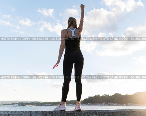 low angle woman standing victorious way. Стоковое фото, агентство Ingram Publishing / Фотобанк Лори