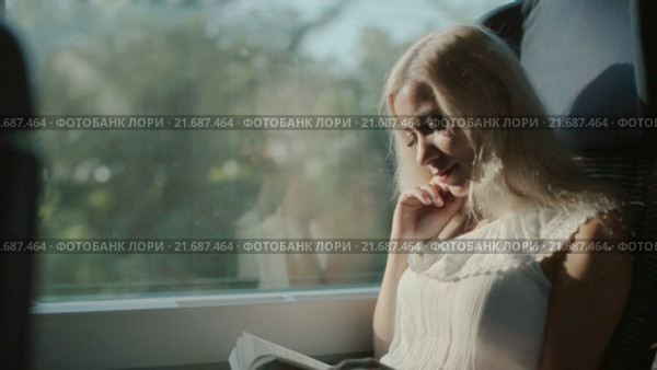 Любознательная блондинка читает книгу. Стоковое видео, видеограф Denis Mishchenko / Фотобанк Лори