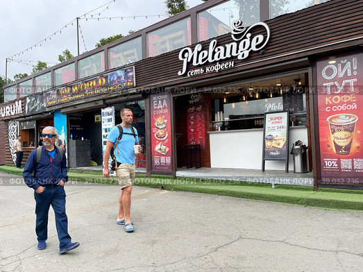 Люди рядом с сетевым кафе Melange на Спортивной набережной во Владивостоке летом (2022 год). Редакционное фото, фотограф Овчинникова Ирина / Фотобанк Лори