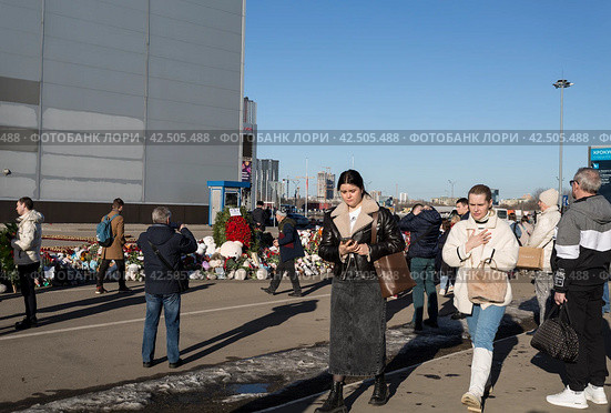 Люди у стихийного мемориала в память о погибших в результате теракта в Крокус Сити Холле. Красногорск, Московская область, Россия (2024 год). Редакционное фото, фотограф Наталья Волкова / Фотобанк Лори