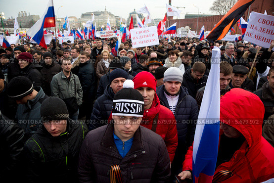 Люди участвуют в многотысячном митинге-концерте на Красной площади в поддержку референдума о вхождении Крыма в состав России (2014 год). Редакционное фото, фотограф Николай Винокуров / Фотобанк Лори