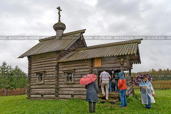 Люди заходят в часовню во имя Святителя Николая Чудотворца. Деревня Гоморовичи Подпорожского района Ленинградской области (2023 год). Редакционное фото, фотограф Румянцева Наталия / Фотобанк Лори