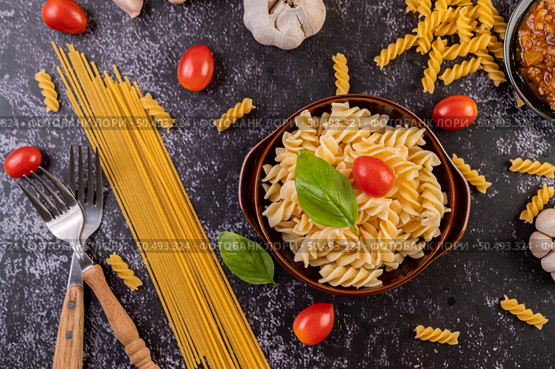 Macaroni sauteed with tomatoes and basil on a gray plate. Стоковое фото, агентство Ingram Publishing / Фотобанк Лори