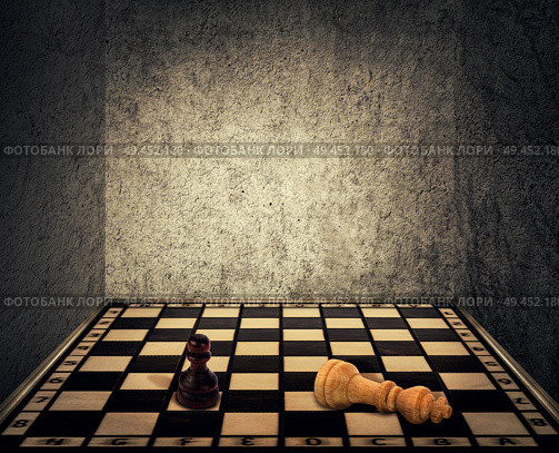 Magical room with a chess board floor surrounded by concrete walls as limitations and the king piece falling down beaten in front of the pawn figure. Business fail and mismanagement concept. Стоковое фото, агентство Ingram Publishing / Фотобанк Лори
