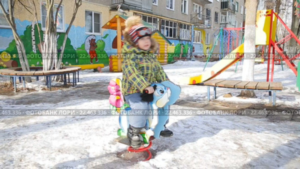 Мальчик катается на качелях в парке зимой (2016 год). Редакционное видео, видеограф Евгений Шишин / Фотобанк Лори