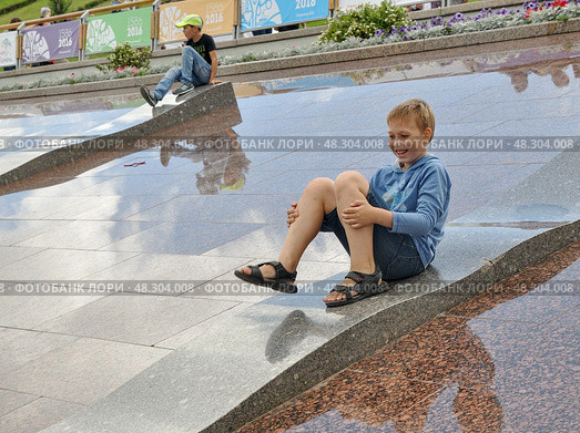 Мальчик скатывается по плитам гранитной набережной. Празднование дня города. Город Тюмень (2016 год). Редакционное фото, фотограф Александр Тараканов / Фотобанк Лори