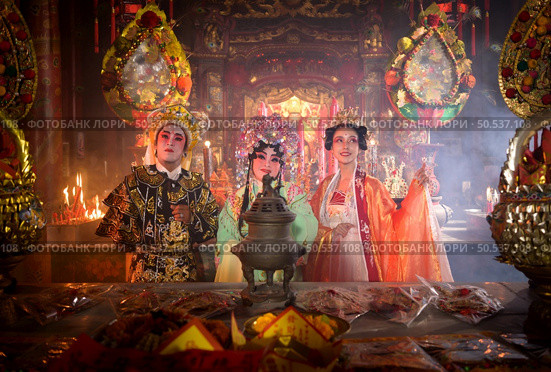Male and female Chinese opera actors Light a candle to pray homage to the gods to enhance the prosperity for yourself on the occasion of the Chinese New Year festival. Стоковое фото, агентство Ingram Publishing / Фотобанк Лори