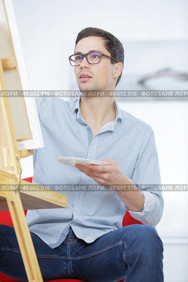 male artist paints on an easel in the workshop. Стоковое фото, агентство Ingram Publishing / Фотобанк Лори
