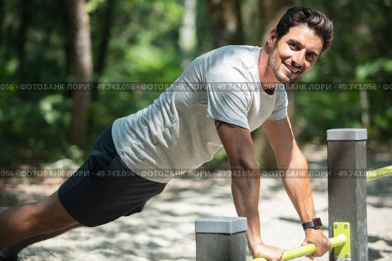 male athlete on parallel bars outdoors. Стоковое фото, агентство Ingram Publishing / Фотобанк Лори