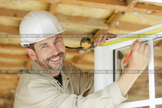 male builder measuring a window. Стоковое фото, агентство Ingram Publishing / Фотобанк Лори