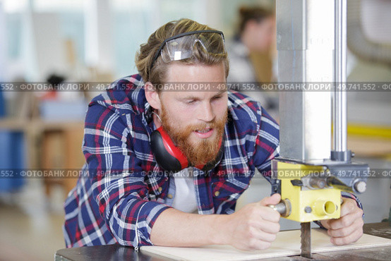 male carpenter is using mechanized vertical saw. Стоковое фото, агентство Ingram Publishing / Фотобанк Лори