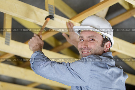 male construction worker builder crouching lywood board. Стоковое фото, агентство Ingram Publishing / Фотобанк Лори