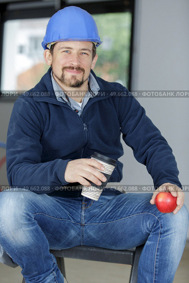 male construction worker eating apple. Стоковое фото, агентство Ingram Publishing / Фотобанк Лори
