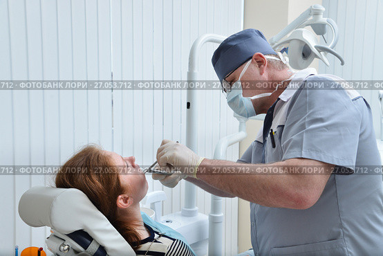 Male Dentist remove tooth of woman patient using forceps. Health care dentistry medicine concept. Стоковое фото, фотограф Сергей Дорошенко / Фотобанк Лори