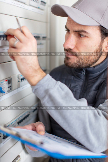 male electrician working on fusebox. Стоковое фото, агентство Ingram Publishing / Фотобанк Лори