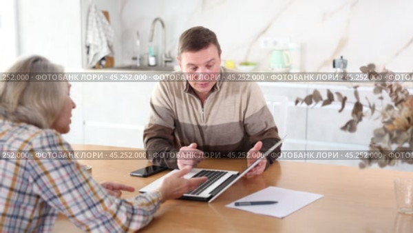 Male financial agent tells an elderly woman the terms of microloan. Offers to sign documents. Стоковое видео, видеограф Яков Филимонов / Фотобанк Лори