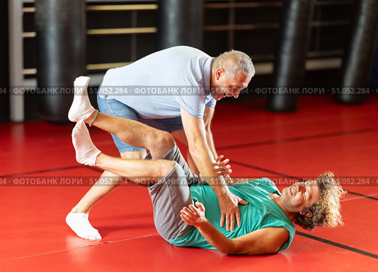 Male pupil clash with training manager during self-defense lesson, repulse charge, intensity of practice. Стоковое фото, фотограф Яков Филимонов / Фотобанк Лори