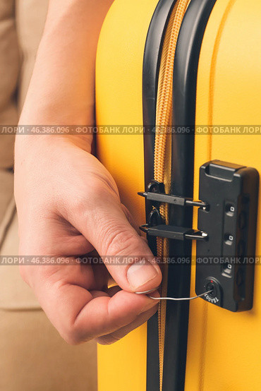 Male thief trying to open stolen suitcase, closeup. Стоковое фото, фотограф Pixel_shot / Фотобанк Лори
