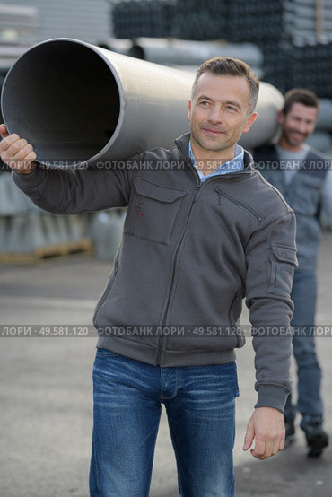 male workers carrying plastic water pipe on their shoulders. Стоковое фото, агентство Ingram Publishing / Фотобанк Лори