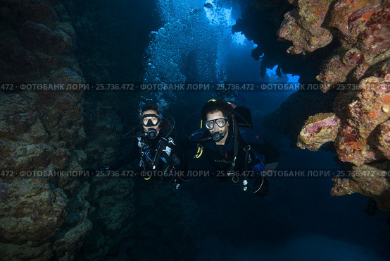 Man and woman scuba divers swimming in the canyon, Red sea, Dahab, Sinai Peninsula, Egypt (2016 год). Редакционное фото, фотограф Некрасов Андрей / Фотобанк Лори