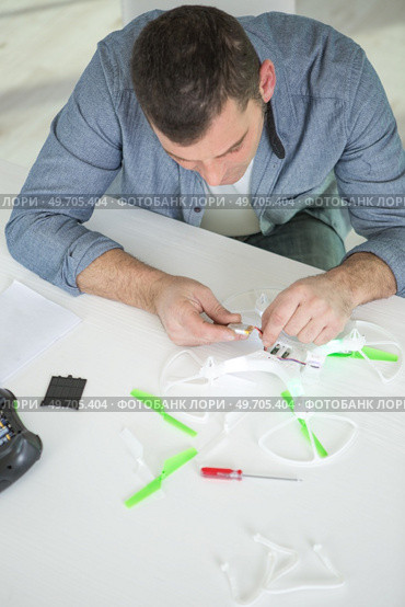 man assembling a drone seen from above. Стоковое фото, агентство Ingram Publishing / Фотобанк Лори