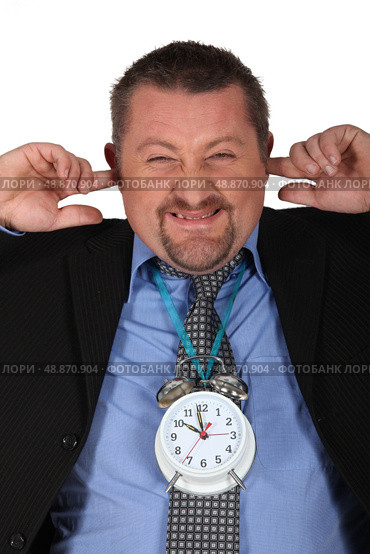 Man blocking his ears because of alarm clock. Стоковое фото, агентство Ingram Publishing / Фотобанк Лори