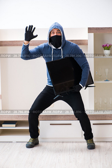 Man burglar stealing tv set from house. Стоковое фото, фотограф Elnur / Фотобанк Лори