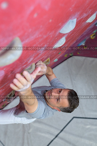man climber on artificial climbing wall in bouldering gym. Стоковое фото, агентство Ingram Publishing / Фотобанк Лори