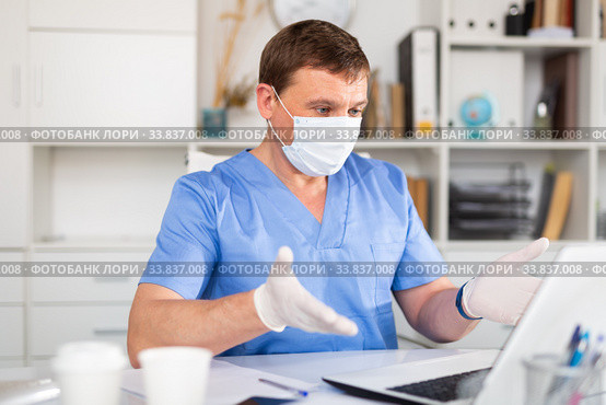 Man doctor in face mask working at laptop. Стоковое фото, фотограф Яков Филимонов / Фотобанк Лори