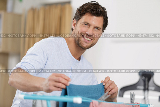 man doing drying cloths at home. Стоковое фото, агентство Ingram Publishing / Фотобанк Лори