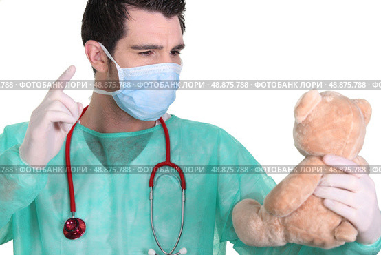 Man dressed as a surgeon quarrelling with teddy bear. Стоковое фото, агентство Ingram Publishing / Фотобанк Лори