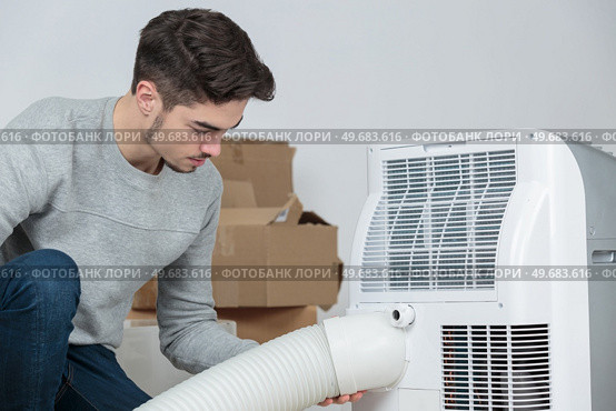 Man fitting hose to ventilation system. Стоковое фото, агентство Ingram Publishing / Фотобанк Лори