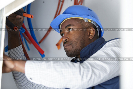man fixing a leaking pipe under the sink. Стоковое фото, агентство Ingram Publishing / Фотобанк Лори