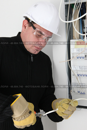 Man fixing fuse box. Стоковое фото, агентство Ingram Publishing / Фотобанк Лори