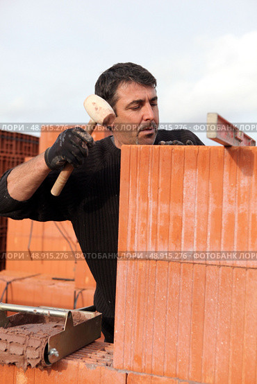 Man hitting wall with mallet. Стоковое фото, агентство Ingram Publishing / Фотобанк Лори