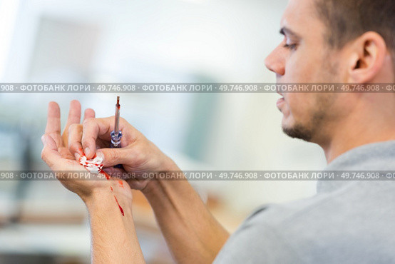 man holding screwdriver and tending bleeding hand. Стоковое фото, агентство Ingram Publishing / Фотобанк Лори