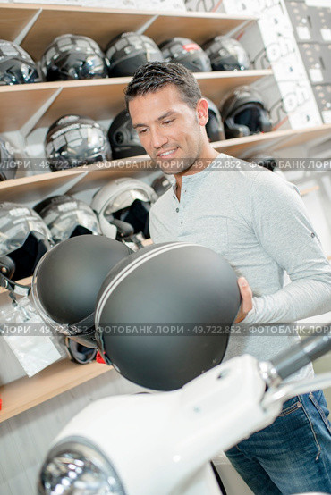 Man holding two crash helmets. Стоковое фото, агентство Ingram Publishing / Фотобанк Лори